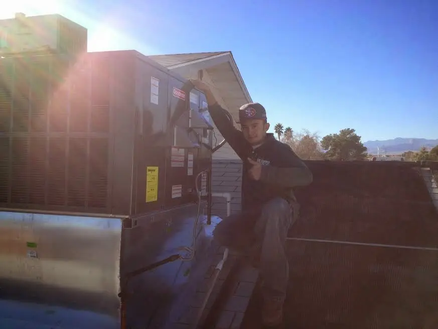 HVAC technician performing AC Tune-Up on a rooftop unit in Lake Shore