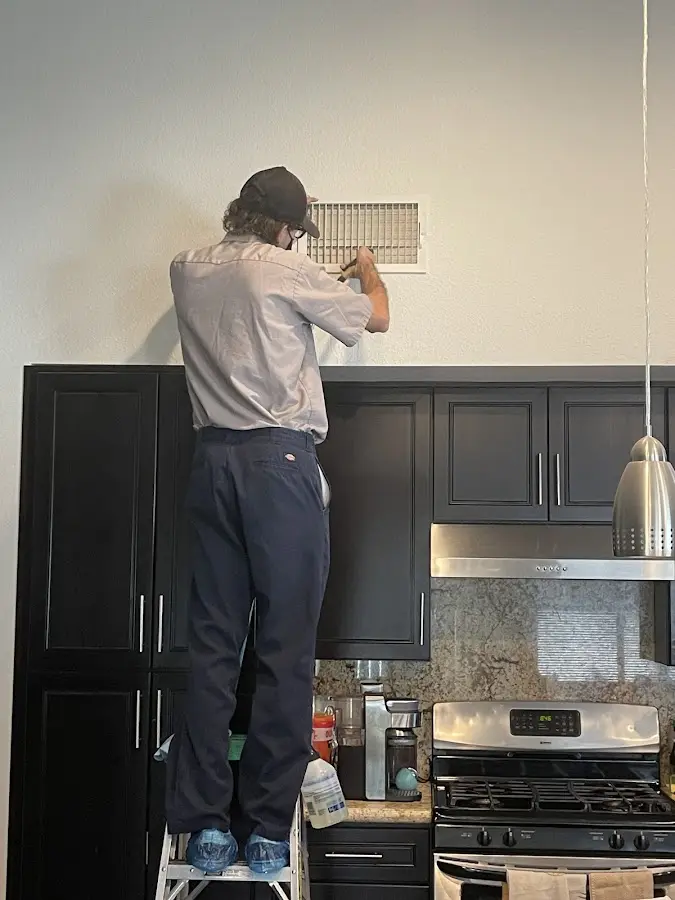 Technician inspecting an air vent during HVAC service in Lake Shore